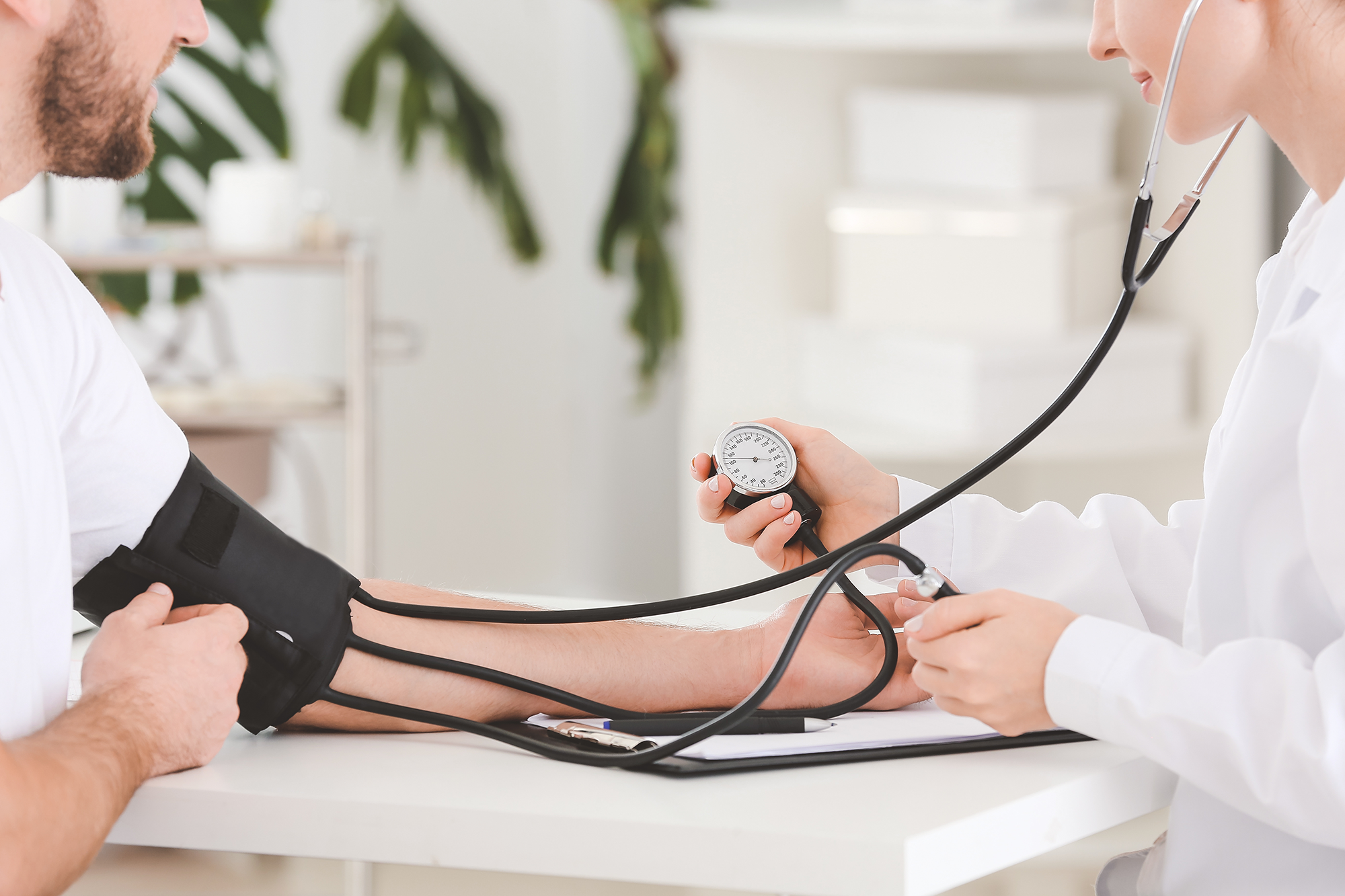 AdobeStock_329465335_mobil Female doctor measuring blood pressure of male patient in hospital
